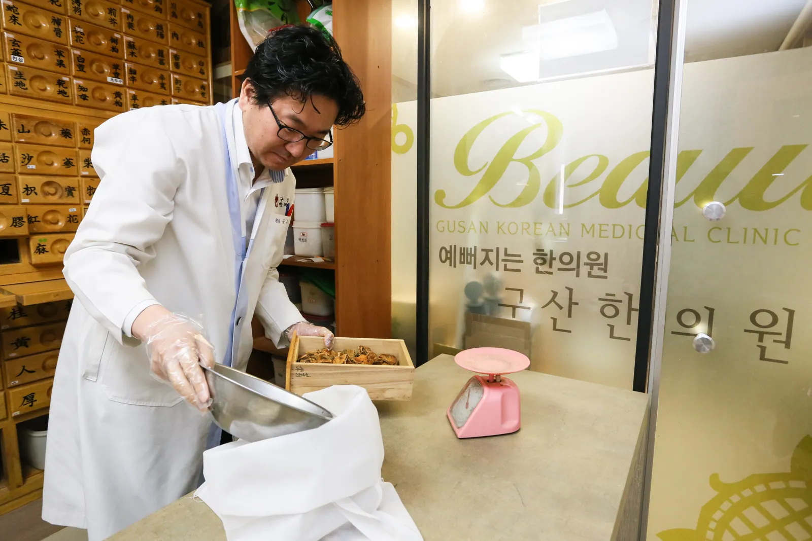 구산한의원 원장이 한약 약재 용량을 직접 확인하며 계량하는 모습